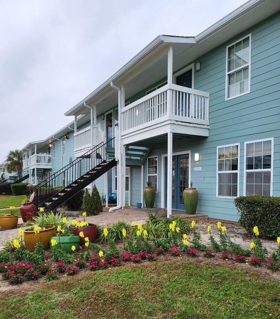 Charming Coastal Curb Appeal: Vibrant Landscaping and Leasing Office at Palm Isle Apartments, Biloxi - Palm Isle Apartment Homes