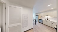 Located at 4759 15th Ave NE in Seattle's vibrant University District, this contemporary single-floor unit offers a thoughtfully designed layout across seven distinct spaces. Light-toned luxury vinyl plank flooring flows throughout, creating a cohesive and easy-to-maintain interior.

The kitchen is equipped with stainless steel appliances — including a refrigerator, dishwasher, and range — complemented by light wood cabinetry, a clean white tile backsplash, and recessed lighting. A built-in dining table with bar stools provides a compact yet functional dining area just steps from the kitchen.

The living area features a large picture window that fills the room with natural light and offers views of the surrounding neighborhood. A wall-mounted mini-split system ensures year-round climate control.

The bedroom is a quiet, well-proportioned retreat with a ceiling fan and ample room for a bed and study desk. Two full bathrooms serve the unit, each finished with light wood vanities, undermount sinks, matte black fixtures, and large mirrors. One bathroom includes a tub/shower combination.

A dedicated in-unit laundry closet houses a full-size Whirlpool front-loading washer and dryer, adding significant convenience. The unit's clean, minimalist aesthetic and functional layout make it a practical and comfortable home in a prime Seattle location.