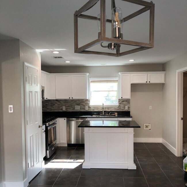 La cocina completamente remodelada cuenta con iluminación empotrada, gabinetes recién pintados y electrodomésticos de acero inoxidable. - 615 Big Spring Dr