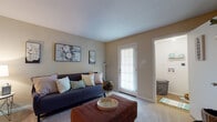 This single-floor residence offers a thoughtfully arranged layout that balances comfort and functionality across its key living spaces. The living room serves as the heart of the home, featuring soft carpeting, warm neutral-toned walls, and a glass door with slatted blinds that fills the room with natural light and provides direct outdoor access. Adjacent to the living area is a cozy dining nook with hardwood-style flooring, ideal for intimate meals. The galley-style kitchen is efficiently designed with white cabinetry, light countertops, a double sink, and a full suite of white appliances, including a range and refrigerator, all complemented by easy-care hardwood-style flooring. The primary bedroom is a relaxing retreat with plush carpet, a ceiling fan, and ample space for a dresser and full-length mirror. The second bedroom offers similar comfort, featuring carpet, a ceiling fan, a window with natural light, and room for both a bed and a dedicated workspace. The bathroom is finished with a wide vanity, light countertops, white cabinetry, hardwood-style flooring, and a tiled tub-shower combination. A dedicated laundry area adds everyday convenience, completing this well-rounded and functional single-level home.
