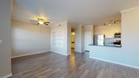 Located at 8000 W Crestline Ave in Denver, Colorado, this single-floor residence offers a well-designed layout with a cohesive blend of comfort and functionality. The open-concept living and dining area is finished with rich hardwood-style flooring, crown molding, and a ceiling fan with light fixture. A fireplace anchors one end of the living room, while large windows allow natural light to fill the space. A sliding glass door provides access to a private outdoor balcony, extending the living area outdoors.

The kitchen is positioned adjacent to the main living area and features a raised breakfast bar peninsula with dark countertops, white cabinetry, and a full suite of stainless steel appliances including a refrigerator, range, and microwave. Track lighting overhead adds a contemporary touch, and a dedicated pantry provides additional storage.

The bedrooms are carpeted for comfort, each offering generous closet space. One bedroom includes a walk-in closet with built-in shelving, while another features direct access to an outdoor patio. The bathroom is appointed with a tiled tub-and-shower combination, dark granite-style countertops, white vanity cabinetry, and wood-look vinyl flooring. Crown molding and neutral tones throughout lend the space a clean, polished aesthetic.