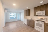 Located at 18730 Miner Ln in Morgan Hill, CA, this well-designed one-bedroom, one-bathroom unit offers a practical and modern living environment across a single floor. Light-toned laminate flooring flows consistently throughout, lending the space a clean, cohesive aesthetic.

The kitchen is a functional highlight, featuring rich medium-toned cabinetry with sleek hardware, white appliances including a refrigerator, electric range, over-the-range microwave, and dishwasher, along with light countertops and a stainless steel sink. Ample upper and lower cabinet storage makes the most of the available space.

The living area is bright and open, benefiting from natural light streaming through windows fitted with horizontal blinds. A wall-mounted mini-split unit provides climate control, ensuring year-round comfort. The space opens conveniently toward the kitchen, creating an easy flow between living and cooking areas.

The bedroom is a comfortable, well-proportioned retreat, featuring a window that invites natural light and a sliding-door closet offering practical storage. White walls throughout maintain a clean, neutral palette.

The bathroom is neatly appointed with a full tub-shower combination, white subway-style tile surround, a curved shower rod, and light flooring, delivering a fresh and functional space. The overall design of the unit emphasizes simplicity, functionality, and a bright, modern atmosphere.
