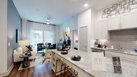 This thoughtfully designed two-bedroom, two-bathroom residence offers a single-floor open-concept layout that maximizes both functionality and style. The kitchen serves as a central hub, featuring granite countertops, a large island with bar seating, white shaker cabinetry, a tile backsplash, and stainless steel appliances including a refrigerator, range, and built-in microwave. Wood-style flooring flows throughout the main living areas, complementing the bright, neutral color palette.

The living room opens directly to a private balcony through a large sliding glass door, allowing abundant natural light and outdoor views. Elevated ceilings and recessed lighting enhance the sense of openness throughout.

Both bedrooms are generously sized with plush carpeting, large windows, and ample natural light. Each bedroom connects to its own bathroom. One bathroom features a soaking tub with subway tile surround, while the other includes a vanity with marble-style countertops and a walk-in closet with built-in shelving. Both bathrooms showcase warm wood-style flooring and clean, modern finishes, creating a cohesive and polished aesthetic throughout the residence.