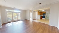 This single-story, 3-bedroom, 2-bathroom home offers a thoughtfully designed layout across a comfortable footprint. The welcoming entrance opens into a bright, open-plan living room and kitchen area, where warm hardwood-style flooring flows throughout the main living spaces. Large French doors with transom windows flood the living room with natural light and provide picturesque views of the surrounding trees and outdoor greenery.

The kitchen features warm honey-toned wood cabinetry, granite-style countertops, and tile flooring, with ample storage and counter space. A dedicated utility room is conveniently accessible from the kitchen. Crown molding and a chandelier add a refined touch to the dining area adjacent to the kitchen.

Each of the three bedrooms is carpeted and generously sized, with large windows that invite natural light and offer serene outdoor views, including glimpses of a nearby pond. The spacious primary bedroom benefits from dual windows and access to a walk-in closet equipped with extensive wire shelving and storage systems. Three closets in total serve the home's storage needs.

The bathrooms are clean and functional, featuring white tiled tub-shower combinations. A hallway connects the private bedroom wing to the main living areas, and a dedicated utility room completes this well-rounded home.
