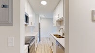 Located at 2450 Island Dr in Spring Park, MN, this one-bedroom, one-bathroom residence offers a thoughtfully designed single-floor layout. Light hardwood-style flooring flows throughout the main living areas, creating a clean, cohesive aesthetic. The open-concept kitchen and living room serves as the heart of the home, with the kitchen showcasing crisp white shaker cabinetry, white quartz countertops, a subway tile backsplash, and stainless steel appliances including a full-size refrigerator, range, and microwave. Generous upper and lower cabinet storage maximizes functionality in the space. The living area is bright and airy, highlighted by a large sliding glass door that opens to lush green outdoor views and allows abundant natural light to fill the room. Baseboard heating and a wall-mounted AC unit provide year-round comfort. The spacious bedroom features plush carpeting, a wide closet with bi-fold doors, and a window overlooking the greenery outside. The bathroom is finished with light wood-style flooring, clean white cabinetry, and a full tub-shower combination. Throughout, the neutral color palette and modern finishes create a fresh, welcoming atmosphere.