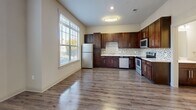 Located at 12821 Little Penny Drive in Huntersville, NC, this three-bedroom, four-bathroom townhome spans three floors, offering a thoughtful layout with ample living space. The ground level provides an entry point into the home, while the main living floor serves as the heart of the residence. The kitchen is a standout feature, showcasing rich dark wood cabinetry, stainless steel appliances including a refrigerator, range, microwave, and dishwasher, complemented by light countertops and a mosaic tile backsplash. Durable hardwood-style flooring runs throughout the kitchen and living areas, while large windows flood the space with natural light. The bathrooms are finished with dark wood vanities, mosaic tile accents, and hardwood-style flooring, offering a cohesive design aesthetic. The three bedrooms are carpeted for comfort and each feature windows with views of the surrounding greenery. The spacious primary bedroom includes a ceiling fan and a generous walk-in closet with built-in shelving. Additional storage is provided by multiple closets throughout the home. With neutral tones, clean finishes, and a practical multi-floor layout, this home offers a well-organized and comfortable living environment.