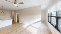 This contemporary 640 square foot apartment, located at 900 Third St SE in Cedar Rapids, Iowa, offers a thoughtfully designed living space on a single floor. The heart of the home is a sleek, L-shaped kitchen featuring crisp white cabinetry, stainless steel appliances, and ample counter space. Modern pendant lighting and recessed fixtures illuminate the cooking area, which opens seamlessly into the living room.

The living area is bright and airy, with large windows that provide city views and flood the space with natural light. Light-toned hardwood flooring runs throughout, creating a sense of continuity and amplifying the apartment's spacious feel. A ceiling fan in the living room aids in air circulation.

Storage is well-considered, with a dedicated closet featuring adjustable wire shelving systems. The open floor plan allows for flexible furniture arrangement, making the most of the available square footage. The apartment's neutral color palette and clean lines contribute to its modern aesthetic, providing a blank canvas for personal styling.

Despite its compact size, this urban dwelling efficiently incorporates all essential living spaces, demonstrating smart space utilization. The apartment's location in downtown Cedar Rapids offers the convenience of city living in a fresh, contemporary setting.