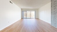 Located at 488 W Duarte Rd in Arcadia, CA, this single-floor, 2-bedroom, 3-bathroom residence offers a thoughtfully designed layout with warm hardwood flooring throughout. The spacious living room is a standout, anchored by a striking floor-to-ceiling painted brick fireplace and large sliding glass doors that open to a private balcony, filling the space with natural light. The kitchen is well-equipped with white cabinetry, stone-toned countertops, stainless steel appliances including a double wall oven, a black matte faucet, and a window that lets in additional natural light. Both bedrooms are generously sized, featuring large windows with vertical blinds and ceiling fans for comfort. The primary bedroom includes dedicated closet space and its own en-suite bathroom, which showcases a sleek white vanity with black hardware and matte fixtures, a framed mirror, and a walk-in closet. The additional bathrooms follow the same clean, modern aesthetic with white cabinetry and black accents. A dedicated laundry room and five closets throughout provide ample storage. The home's neutral palette, consistent hardwood flooring, and modern fixtures create a cohesive and inviting ambiance throughout.