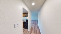 This Summit West apartment, unit 8A-C2, offers a generous 1050 square feet of living space on a single floor. The layout includes three bedrooms, with the primary bedroom boasting 180 square feet, two full bathrooms, and a combined kitchen and living room area. The interior is characterized by sleek hardwood flooring throughout, creating a warm and cohesive aesthetic.

Large windows in the bedrooms and living areas flood the space with natural light, enhancing the open feel. The kitchen is equipped with modern black appliances, including a refrigerator and range, complemented by honey-toned wooden cabinetry and ample counter space. A convenient breakfast bar adds functionality to the kitchen design.

The bathrooms feature a clean, contemporary look with white fixtures and wooden vanities. One bathroom includes a shower-tub combination, while the other offers a standing shower. Both bedrooms and living spaces are fitted with practical closets for storage.

The apartment's neutral color palette, predominantly white walls, allows for personal decorating preferences. Recessed lighting in some areas and a ceiling fan in the living room provide additional comfort and ambiance. This well-designed space offers a balance of functionality and style, suitable for comfortable modern living.