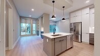 This contemporary single-story residence offers 1230 square feet of thoughtfully designed living space. The home boasts two bedrooms, including a spacious primary bedroom of 190 square feet, and an impressive four bathrooms, ensuring comfort and convenience for residents and guests alike. The interior is characterized by a modern aesthetic, featuring light wood-look flooring and a neutral color palette that creates a bright, airy atmosphere. 

The open floor plan seamlessly integrates the kitchen and living areas, promoting a sense of spaciousness and facilitating easy entertaining. Clean lines and minimalist design elements are evident throughout, with recessed lighting adding a touch of sophistication. The property includes two closets for ample storage, and a hallway that connects the various living spaces.

Modern door designs with sleek paneling complement the contemporary ambiance, while large baseboards add a refined touch to the rooms. The bathrooms, glimpsed through doorways, appear to feature updated fixtures and finishes. Overall, this home combines functionality with style, offering a turnkey living experience in a fresh, modern setting.