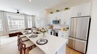 This 1,160 sq ft, three-story townhome at 4500 Beech St in Norwood, OH offers a well-designed layout across three distinct floors totaling 180, 510, and 480 square feet respectively. The bright, open-concept main level features a sleek kitchen outfitted with white shaker cabinetry, black hardware, stainless steel appliances, a subway tile backsplash, and a large island with seating for three — ideal for dining and entertaining. The adjacent living room benefits from oversized windows, hardwood-style flooring, and a ceiling fan, creating an airy, light-filled atmosphere. Upstairs, the primary bedroom spans 140 sq ft and includes plush carpeting, a ceiling fan, and ample natural light, complemented by a full en-suite bathroom featuring a glass-enclosed walk-in shower, dual-sink vanity with white quartz countertops, and wood-look flooring. A second bedroom and an additional full bathroom with a tub/shower combo and white vanity provide comfortable accommodations. A dedicated office space with hardwood-style flooring and a ceiling fan offers a functional work-from-home environment. Three closets, two hallways, and a central staircase complete this thoughtfully organized home.