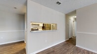 This well-appointed 2-bedroom, 2-bathroom residence is thoughtfully laid out across a single floor, making efficient use of its space. The living room serves as the heart of the home, featuring durable wood-look flooring, a ceiling fan, a tile-surround fireplace, and a sliding glass door that opens to a private outdoor patio, allowing natural light to fill the room. A pass-through window with a marble-style ledge connects the living area to the galley-style kitchen, which is outfitted with white cabinetry, granite-look countertops, subway tile backsplash, and full appliances including a refrigerator, range, and dishwasher. A pantry closet provides additional storage. Both bedrooms are carpeted and include closets, ceiling fans, and windows that bring in natural light. The primary bedroom is a comfortable, well-proportioned retreat. The two bathrooms are finished consistently with wood-look flooring, marble-style countertops, white vanity cabinetry, and large mirrors. One bathroom features a tub-shower combination. A hallway connects the bedrooms and bathrooms, completing the practical floor plan. Textured ceilings are found throughout, and neutral wall tones create a clean, cohesive aesthetic across the entire residence.