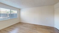 Located at 594 S Madera Ave in Madera, CA, this two-story residence offers a thoughtfully arranged layout spread across two floors. The main level welcomes you through a dedicated entrance that opens to a combined kitchen and living room area, complete with light hardwood-style flooring throughout. The living room is anchored by a striking corner fireplace finished with warm terra-cotta tile surrounds, adding character and a cozy focal point to the space. The kitchen is well-appointed with rich wood cabinetry, granite-look countertops, a stainless steel sink, and white appliances including a range, dishwasher, and refrigerator. A convenient in-unit laundry area with a full-size washer and dryer is tucked just off the kitchen. Upstairs, the generously sized bedroom provides a comfortable retreat, featuring plush carpeting, bright windows with outdoor views of the surrounding neighborhood, and direct access to the full bathroom. The bathroom is clean and functional, featuring a wood-tone vanity, tile flooring, and a window for natural light. A hallway connects the upper-floor spaces seamlessly. Textured ceilings, white walls, and consistent wood-style flooring on the main level give the home a bright, cohesive aesthetic throughout.