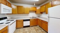 Located at 1170 Northwood Dr in Eagan, Minnesota, this two-floor property offers a functional and well-maintained layout designed for comfortable everyday living. The kitchen is outfitted with warm oak cabinetry that extends to the ceiling, light-toned laminate countertops, a double-basin sink, a dishwasher, and a range, all set atop durable tile flooring — providing ample storage and workspace. The living areas are generously sized, featuring plush wall-to-wall carpeting, wood baseboards, and textured ceilings throughout. Large windows dressed with vertical blinds allow natural light to filter in and offer views of the surrounding greenery. The entry area features a solid six-panel wood door and opens into a spacious carpeted main living space. Multiple bathrooms are present, each featuring tub and shower combinations with tiled surrounds, tile flooring in earthy tones, and warm wood vanities with light countertops and large mirrors. Bedrooms are well-proportioned with soft carpeting and neutral walls, and at least one includes a walk-in style closet with built-in wire shelving and rods for organized storage. The overall ambiance is clean, neutral, and move-in ready, making this property a practical and comfortable option in the Eagan community.