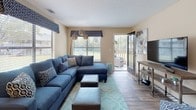 This single-story, two-bedroom, two-bathroom residence offers a thoughtfully organized layout designed for comfortable everyday living. The living room serves as the central gathering space, featuring wood-style flooring, multiple windows that invite natural light, and a sliding glass door opening directly onto a private balcony. A dedicated dining area adjacent to the living room is accented by a chandelier, adding a refined touch to the space.

The galley-style kitchen is equipped with dark wood cabinetry, black appliances including a gas range and refrigerator, light countertops, a double basin sink, and wood-style flooring. A walk-in pantry or utility closet is accessible directly from the kitchen.

Both bedrooms feature plush carpeting and ceiling fans with integrated lighting. The primary bedroom includes multiple windows and ample room for a full furniture arrangement, while the second bedroom offers sliding glass door access to an outdoor balcony. Each bedroom is served by its own full bathroom, both featuring a tub-shower combination with tile surround, a vanity, and wood-style flooring, providing privacy and convenience for residents and guests alike.