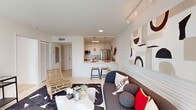 Located in the heart of Miami's prestigious Brickell neighborhood, this one-bedroom, one-bathroom apartment offers a well-designed open-concept layout that maximizes every inch of its thoughtfully appointed floor plan. The combined living and kitchen area serves as the centerpiece of the home, bathed in natural light streaming through large floor-to-ceiling sliding glass doors that open to lush tropical views — a quintessentially Miami backdrop. The living area features a textured accent wall, track lighting, and light-toned tile flooring that enhances the bright, airy atmosphere throughout. The kitchen is outfitted with white cabinetry extending to the ceiling, a subway tile backsplash, stainless steel appliances including a refrigerator, microwave, and range, as well as a white quartz peninsula with bar seating — ideal for casual dining. The spacious bedroom offers natural light through a large window, neutral carpeting, and a dedicated closet for ample storage. The full bathroom features a tub-shower combination with clean white tile surround, a floating vanity, and a large mirror. The overall ambiance of the space is clean, modern, and effortlessly coastal — perfectly suited to the vibrant Miami lifestyle.