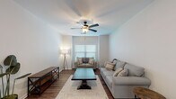 Located in Oxford, Mississippi, this single-story, 3-bedroom, 3-bathroom home offers a practical and comfortable layout designed for everyday living. The living room serves as the heart of the home, featuring rich wood-look flooring, neutral-toned walls, and a ceiling fan with light fixture. Natural light filters in through blinds-fitted windows, creating a warm and inviting atmosphere. The open kitchen is equipped with rich walnut-toned cabinetry, stainless steel appliances including a refrigerator, over-the-range microwave, and electric range, along with a double-basin sink and light countertops. A peninsula counter separates the kitchen from the dining area, which accommodates a full dining set. Each of the three bedrooms provides a comfortable retreat, with wood-look flooring, ceiling fans, and windows that allow natural light. The bedrooms include closets with built-in shelving for ample storage. The three bathrooms are consistently finished with wood-toned vanities, white countertops, and shower-tub combinations. Throughout the home, the consistent use of wood-look flooring and neutral wall tones creates a cohesive, clean aesthetic well-suited for comfortable residential living.