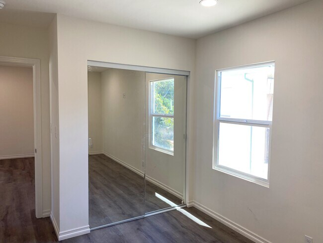bedroom with mirror closet doors - 12230 W Magnolia Blvd
