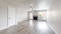Located at 2300 Seminole Dr in Arlington, TX, this two-story home offers three bedrooms and three bathrooms across two well-proportioned floors. The main level features an open-concept living room and kitchen layout, where light-toned wood-look flooring runs seamlessly throughout. The living room is anchored by a charming stone fireplace and large windows fitted with blinds that invite natural light, complemented by a ceiling fan overhead and a textured ceiling. The kitchen is well-appointed with white shaker-style cabinetry, granite countertops, a subway tile backsplash, and stainless steel appliances including a refrigerator and dishwasher. The bathrooms are tastefully finished with granite vanity tops, framed mirrors, and clean white fixtures, with at least one featuring a full tub-and-shower combination. Upstairs, the bedrooms continue the wood-look flooring theme, each with ceiling fans, natural light from blinds-covered windows, and closets — including a walk-in closet in one of the rooms. Neutral gray walls throughout lend a clean, cohesive aesthetic. A staircase connects both levels, and hallways provide practical flow between rooms, making this a functional and modern home.
