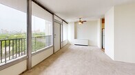 Located at 801 Thornton Street Southeast in Minneapolis, MN, this two-bedroom, two-bathroom residence offers a well-organized single-level layout with a thoughtful mix of functional spaces. The living room is a standout feature, showcasing floor-to-ceiling windows that frame sweeping views of the surrounding cityscape and greenery. A ceiling fan adds comfort, and direct access to the private balcony extends the living area outdoors. The galley-style kitchen runs parallel countertops with ample white cabinetry, warm-toned countertops, and tile flooring, with an open sightline to the living area and balcony beyond. Both bedrooms are carpeted and feature natural light; the primary bedroom is generously sized and includes an expansive wall of louvered bifold closet doors for substantial storage. The second bedroom also benefits from a large window with city views. Five closets are distributed throughout the unit, providing exceptional storage capacity. The two bathrooms feature mosaic tile flooring, vanities with wide mirrors, and full-size tub and shower combinations. The entry hallway is finished with wood-look plank flooring and additional louvered closet doors. Neutral tones and clean lines throughout create a bright, cohesive atmosphere.