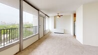 Located at 801 Thornton Street Southeast in Minneapolis, MN, this two-bedroom, two-bathroom residence offers a well-organized single-level layout with a thoughtful mix of functional spaces. The living room is a standout feature, showcasing floor-to-ceiling windows that frame sweeping views of the surrounding cityscape and greenery. A ceiling fan adds comfort, and direct access to the private balcony extends the living area outdoors. The galley-style kitchen runs parallel countertops with ample white cabinetry, warm-toned countertops, and tile flooring, with an open sightline to the living area and balcony beyond. Both bedrooms are carpeted and feature natural light; the primary bedroom is generously sized and includes an expansive wall of louvered bifold closet doors for substantial storage. The second bedroom also benefits from a large window with city views. Five closets are distributed throughout the unit, providing exceptional storage capacity. The two bathrooms feature mosaic tile flooring, vanities with wide mirrors, and full-size tub and shower combinations. The entry hallway is finished with wood-look plank flooring and additional louvered closet doors. Neutral tones and clean lines throughout create a bright, cohesive atmosphere.