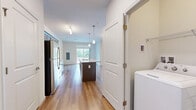Located at 40 Red Mill Rd in Etters, PA, this single-floor, 2-bedroom, 1-bathroom home offers a thoughtfully designed layout that maximizes functionality and comfort. The heart of the home is an open-concept kitchen and living area featuring warm hardwood-style flooring, dark espresso cabinetry, a white subway tile backsplash, and a central island with a light stone countertop and built-in sink. Pendant lighting and a track fixture illuminate the space, while stainless steel appliances — including a refrigerator, range, and microwave — add a modern touch. A sliding glass door off the kitchen/living area invites natural light and provides outdoor access. The two bedrooms are finished with plush neutral carpeting and crisp white walls, creating a calm and restful atmosphere. The primary bedroom offers a comfortable footprint with a large window dressed in white blinds that fills the room with natural light. The shared full bathroom features warm wood-tone flooring, a dark vanity with a white countertop, a large mirror, and overhead vanity lighting. A dedicated closet provides convenient storage. The overall aesthetic is clean, neutral, and move-in ready, making this home an inviting and practical living space.