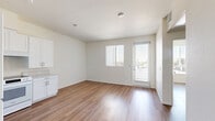 Located at 5270 Balboa Ave in San Diego's Clairemont neighborhood, this one-bedroom, one-bathroom unit offers a well-organized single-floor layout designed for comfortable everyday living. Warm-toned wood-look flooring runs throughout the entire unit, creating a cohesive and easy-to-maintain interior.

The kitchen is a standout feature, outfitted with crisp white shaker-style cabinetry extending to the ceiling, light-toned countertops, and a full suite of white appliances including a refrigerator, electric range, dishwasher, and sink. The open layout allows the kitchen to flow naturally into the living area, creating a bright and airy communal space filled with natural light.

The bedroom is a comfortable, private retreat featuring a large window dressed with vertical blinds that filter in generous natural light and offer views of the surrounding area. The room provides a clean, neutral canvas with white walls and continued wood-look flooring.

The bathroom is thoughtfully designed with accessibility in mind, featuring grab bars, a vanity with under-sink cabinetry, a wall-mounted mirror, and a walk-in shower area, all finished in a clean white palette with warm wood-look flooring. A private balcony extends the living space outdoors, offering an additional area to relax. Two hallways connect the rooms efficiently throughout the unit.