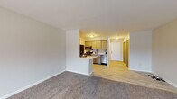 Located at 510 College Ave NE in Grand Rapids, Michigan, this single-floor unit offers a clean, functional layout designed for comfortable everyday living. The open-concept design seamlessly connects the living area and kitchen, creating a cohesive and airy feel throughout the space.

The living area is generously sized, featuring plush wall-to-wall carpeting and neutral-toned walls that lend a warm, understated ambiance. A large window along one wall invites natural light into the room, adding brightness and a connection to the outdoors.

Transitioning into the kitchen, the space is finished with light wood-grain cabinetry, light-colored countertops, and a classic subway tile backsplash. Stainless steel appliances — including a range, over-the-range microwave, and dishwasher — provide a modern touch. A peninsula counter serves as both a prep area and casual dining space, bridging the kitchen and living areas with ease. Light hardwood-style flooring runs through the kitchen and connecting hallway, providing a practical contrast to the carpeted living space.

A hallway leads to additional areas of the unit, including the bathroom, which features tile flooring, a shower/tub combination, and a wood-paneled door adding a natural accent. The overall design is straightforward and well-maintained, making this a practical and inviting space.