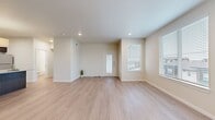 This single-floor, 2-bedroom, 2-bathroom residence offers a thoughtfully designed layout that balances comfort and functionality. The open living area is bathed in natural light from multiple large windows fitted with horizontal blinds, highlighting the warm, light-toned wood-style flooring that extends throughout the home. Recessed lighting and clean white ceilings contribute to a bright, airy ambiance.

The kitchen serves as a central feature, showcasing dark espresso cabinetry, stainless steel appliances, a subway tile backsplash, and a generous granite-topped island with an undermount sink — ideal for both cooking and casual dining.

The primary bedroom offers a comfortable footprint, complete with a ceiling fan, a window for natural light, and access to a walk-in closet outfitted with wire shelving for organized storage. The second bedroom is equally well-lit with its own access to storage.

Both bathrooms are finished with granite-topped dark wood vanities and tiled tub-shower surrounds featuring a classic basketweave pattern, lending a clean, contemporary aesthetic.

A hallway connects the rooms efficiently, and two dedicated closets provide ample storage throughout. The entry area features a windowed door that frames outdoor views, reinforcing the home's connection to natural light and the surrounding environment.