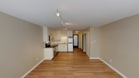 Located at 2000 Walnut St in the heart of Boulder, Colorado, this single-floor unit offers a thoughtfully designed open layout that seamlessly connects the living area and kitchen. The space features light hardwood flooring throughout, lending warmth and continuity from room to room.

The kitchen is outfitted with stainless steel appliances, including an electric range, built-in microwave, and refrigerator. White cabinetry provides ample storage, while a clean countertop and sink complete the functional workspace. Track lighting runs along the ceiling, providing excellent illumination across the kitchen and living areas.

The main living area is bright and open, benefiting from natural light streaming in through a set of windows along one wall. A baseboard heating system ensures year-round comfort. Neutral beige walls throughout the unit create a clean, versatile backdrop ready for personalization.

The hallway connects the main living space to additional rooms, including a bathroom featuring a tiled tub and shower combination, a toilet, and a frosted privacy window that brings in soft natural light. The overall layout makes efficient use of space, offering a comfortable and functional environment.

Situated in vibrant Boulder, CO, this unit combines practical amenities with a clean, modern aesthetic in one of Colorado's most desirable cities.