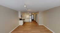 Located at 2000 Walnut St in the heart of Boulder, Colorado, this single-floor unit offers a thoughtfully designed open layout that seamlessly connects the living area and kitchen. The space features light hardwood flooring throughout, lending warmth and continuity from room to room.

The kitchen is outfitted with stainless steel appliances, including an electric range, built-in microwave, and refrigerator. White cabinetry provides ample storage, while a clean countertop and sink complete the functional workspace. Track lighting runs along the ceiling, providing excellent illumination across the kitchen and living areas.

The main living area is bright and open, benefiting from natural light streaming in through a set of windows along one wall. A baseboard heating system ensures year-round comfort. Neutral beige walls throughout the unit create a clean, versatile backdrop ready for personalization.

The hallway connects the main living space to additional rooms, including a bathroom featuring a tiled tub and shower combination, a toilet, and a frosted privacy window that brings in soft natural light. The overall layout makes efficient use of space, offering a comfortable and functional environment.

Situated in vibrant Boulder, CO, this unit combines practical amenities with a clean, modern aesthetic in one of Colorado's most desirable cities.