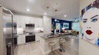This thoughtfully designed single-floor residence combines modern aesthetics with practical functionality throughout its open, well-appointed layout. The kitchen is a standout feature, showcasing white shaker cabinetry, dark countertops, a marble-style tile backsplash, stainless steel appliances including a French door refrigerator, electric range, built-in microwave, and dishwasher, as well as open shelving and a center island with bar seating — ideal for both everyday living and entertaining. The kitchen flows seamlessly into the dining and living areas, where a bold deep-blue accent wall serves as a dramatic backdrop for the living space, complemented by light wood-look flooring that runs throughout. The bedroom offers a serene retreat, highlighted by a vibrant green accent wall, a ceiling fan, large windows with natural light, and direct access to a generously sized walk-in closet with built-in wire shelving. The bathroom features a long vanity with a dark countertop, an undermount sink, and large-format tile work. A dedicated in-unit laundry area with a full-size washer and dryer adds everyday convenience. Recessed lighting and neutral wall tones throughout contribute to a clean, contemporary ambiance.