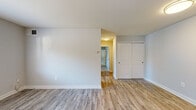 This single-floor residence offers a clean, updated interior with a cohesive design aesthetic carried throughout. The main living area is spacious and bright, featuring light-toned luxury vinyl plank flooring and neutral gray walls that create a fresh, modern feel. A double sliding-door closet and direct hallway access add to the functionality of this room. The galley-style kitchen is well-equipped with rich dark wood cabinetry, light granite-style countertops, and a full suite of stainless steel appliances including a gas range, over-the-range microwave, and dishwasher. A window above the range brings in natural light, enhancing the space. The bedrooms feature plush carpeting and generous closet solutions — one bedroom includes a walk-in closet with built-in shelving, while another offers a standard closet with ample storage. Additional rooms with vinyl plank flooring provide flexible use. The bathroom is cleanly finished with a full tub-shower combo, white tile surround, a dark wood vanity with an integrated sink, and coordinating hardware. Throughout the unit, clean white trim and neutral tones create a bright, move-in-ready atmosphere.