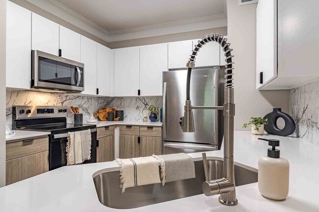 Newly renovated kitchen with quartz countertops, stainless steel appliances and two toned cabinets - Waterstone at Big Creek Apartments