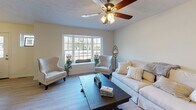 Located at 155 Champion Ave in Webster, NY, this two-floor home offers a welcoming and functional layout across both levels. The living room is a standout space, centered around a large bay window that floods the room with natural light and offers pleasant views of the surrounding neighborhood. Light hardwood-style flooring, a ceiling fan, and neutral warm tones create an inviting atmosphere. Adjacent to the living room is a dedicated dining area with exterior door access and window views, providing a comfortable space for everyday meals. The kitchen is well-equipped with rich dark cabinetry, light countertops, and a full suite of stainless steel appliances including a side-by-side refrigerator, electric range, and over-the-range microwave. The bedrooms feature plush gray carpeting, ceiling fans, and generous closet space, including double closet doors in the primary bedroom. The bathrooms are clean and functional — one features dark slate-style tile flooring with a tub-shower combination, while the other offers light wood-style flooring and a dark vanity with a white countertop. Throughout the home, neutral wall tones and consistent finishes create a cohesive, move-in-ready feel suited for comfortable everyday living.