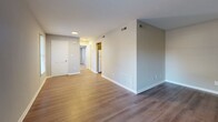 Located at 4415 Deborah Ct in Chesapeake, Virginia, this single-floor, 1-bedroom, 1-bathroom residence offers a clean, functional layout with a cohesive design throughout. The living area features rich wood-style flooring and warm neutral wall tones, with multiple windows fitted with blinds that allow natural light to fill the space. The open sightlines from the living room toward the kitchen and hallway create a sense of flow and connectivity throughout the home. The kitchen is equipped with a gas range, dishwasher, and a refrigerator, complemented by gray cabinetry, white countertops, a tile backsplash, and wood-style flooring that ties the space together. A hallway connects the main living areas to the private bedroom and bathroom. The spacious primary bedroom is carpeted for comfort and features two windows that invite natural light, along with a dedicated closet. Additional closets throughout the home provide ample storage. The bathroom includes a full tub-shower combination with white tile surround and chrome fixtures, maintaining the home's clean and bright aesthetic. With three closets total and a practical single-level floor plan, this residence offers comfortable, efficient living in Chesapeake, VA.