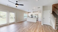 This two-story home in Cartersville, GA offers a well-organized layout spread across two floors. The main level features an open-concept kitchen and living area finished with light hardwood flooring throughout. The kitchen is equipped with white shaker cabinets accented by matte black hardware, granite countertops, stainless steel appliances, and pendant lighting — a functional and stylish space for everyday living. The living room benefits from multiple windows that invite natural light, complemented by a ceiling fan with track lighting overhead. An attached garage with a concrete floor and accessible electrical panel provides practical utility.

Upstairs, three bedrooms offer comfortable accommodations, including a generously sized primary bedroom with plush carpeting and a double-door closet. The upper floor also includes a hallway connecting all rooms. Three full bathrooms serve the home, featuring clean white finishes, wood-look tile or hardwood flooring, and a tub-shower combination with chrome fixtures in one bathroom. Throughout the home, a neutral color palette of warm beige and gray tones creates a cohesive and calming ambiance. White panel doors and clean baseboards add a polished, move-in-ready feel to every room.