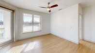 Located at 2600 Lakefront Trail in Rockwall, TX, this well-appointed 2-bedroom, 2-bathroom residence offers a thoughtfully designed single-floor layout filled with natural light and modern finishes throughout. The open-concept living area seamlessly connects the dining and kitchen spaces, creating an inviting atmosphere ideal for both everyday living and entertaining. The kitchen is a standout feature, boasting granite countertops, a large center island with an undermount sink, stainless steel appliances, a decorative tile backsplash, taupe cabinetry, pendant lighting, and a dedicated built-in wine rack. Light hardwood-style flooring flows through the main living areas, complementing the bright, neutral color palette. A private balcony with glass-paned doors and generous windows allows abundant natural light and outdoor views. The primary bedroom offers comfortable proportions, a ceiling fan, and hardwood-style flooring, while the second bedroom features plush carpet and neighborhood views. Both bedrooms benefit from multiple closets, including spacious walk-in closets with wire shelving systems. The bathrooms are finished with granite vanities and grey cabinetry. Additional conveniences include a dedicated laundry area, a pantry, and a mudroom-style entry with built-in coat hooks.