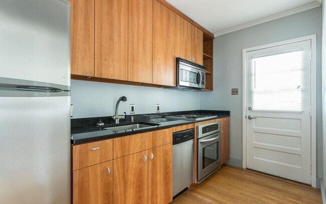 Updated modern cabinetry and stainless appliances. Dishwasher, microwave, and electric cooktop and oven. Under cabinet lighting makes preparing foods easy. - 631 Daniels St