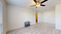This single-floor residence offers a clean, well-maintained interior with a thoughtfully designed layout. The main living area is bathed in natural light from a front-facing window and features light-toned hardwood-style flooring that extends throughout the common areas. A ceiling fan with a built-in light fixture serves as a functional centerpiece overhead, contributing to the room's airy, open feel. The front entry door opens directly into this welcoming living space, which provides a generous sense of openness.

The galley-style kitchen is efficiently arranged with white shaker cabinetry lining both sides, granite-style countertops, a white subway tile backsplash, and black appliances including a refrigerator and range. A flush-mount ceiling light provides practical illumination throughout.

The bedroom offers plush wall-to-wall carpeting, a ceiling fan, and a window that allows natural light to fill the space. The bathroom is outfitted with a full tub-shower combination featuring white tile surround, hardwood-style flooring, and a clean, neutral color palette throughout.

Overall, the space presents a bright, neutral aesthetic with consistent finishes, making it a versatile and move-in ready environment.