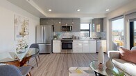 Located at 1716 N Main St in Walnut Creek, California, this single-floor residence offers a thoughtfully designed living space with modern finishes throughout. The open-concept kitchen is a standout feature, showcasing two-tone cabinetry with glossy white lower cabinets and matte gray upper cabinets, a decorative marble-style tile backsplash, and a full suite of stainless steel appliances including a gas range, microwave, refrigerator, and dishwasher. Light wood-look flooring flows seamlessly through the kitchen and into the adjacent dining area, which comfortably accommodates a glass-top dining table. Recessed lighting and a tray ceiling detail add architectural interest to this area. The bedroom is carpeted and features a spacious sliding-door closet, providing ample storage, along with soft neutral tones that create a calm, restful atmosphere. The bathroom is well-appointed with large-format tile flooring, a modern vanity with a gray countertop, and a glass-enclosed walk-in shower adorned with marble-style tile surround. A convenient stacked washer and dryer unit is also included within the space, adding everyday practicality. Overall, the unit presents a clean, contemporary aesthetic suited for comfortable urban living in Walnut Creek.