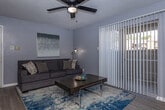 Located at 1350 Greens Pkwy in Houston, Texas, this single-floor residence offers a thoughtfully designed layout with a comfortable and cohesive aesthetic throughout. The living room serves as the heart of the home, featuring wood-look flooring, a ceiling fan with light fixture, and large sliding glass doors with vertical blinds that invite natural light and provide access to the outdoors. The open entryway flows seamlessly into the living and dining areas, creating a connected and functional common space. The dining area is positioned adjacent to the kitchen, which is equipped with white cabinetry, light countertops, a double-basin sink, a dishwasher, and black appliances including a refrigerator and range. A dedicated dining nook with wood flooring provides a practical space for everyday meals. The two bedrooms are finished with plush carpeting and feature windows with blinds that allow for natural light and privacy. Each bedroom offers ample space for full-sized furnishings. The bathroom is clean and efficiently designed, featuring a tub-shower combination, a vanity with storage, and wood-look flooring. Cool gray tones carry throughout the residence, lending a modern and cohesive ambiance to the entire space.