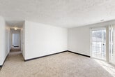 Located at 1106 Marshall Ave in Council Bluffs, Iowa, this single-floor, three-bedroom, two-bathroom home offers a practical and well-organized layout. The living room is a bright, open space featuring neutral wall-to-wall carpeting, crisp white walls with dark baseboards, and a textured ceiling. A sliding glass door with vertical blinds provides access to an outdoor deck and allows natural light to fill the room. The hallway connects the living area to the three bedrooms, each finished with the same soft carpeting and white walls. The primary bedroom offers a generous amount of space, while the two additional bedrooms are well-suited for various uses. The galley-style kitchen is efficiently designed with warm oak cabinetry, light stone-look countertops, wood-style vinyl flooring, and included appliances such as a dishwasher and refrigerator. The two bathrooms are clean and functional, featuring a full tub-shower combination with chrome fixtures and white surrounds. Throughout the home, the consistent use of neutral tones and clean finishes creates a cohesive, move-in-ready atmosphere that offers a solid foundation for comfortable everyday living.