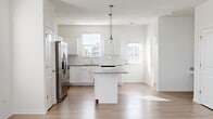 Located at 260 Starling Circle in Oswego, Illinois, this two-story home offers a thoughtfully designed layout spread across two floors. The main level is the larger of the two and features an open-concept kitchen and living area, bathed in natural light from multiple windows fitted with blinds. The kitchen is a standout space, showcasing crisp white shaker cabinetry, granite countertops, a central island with pendant lighting, subway tile backsplash, and a full suite of stainless steel appliances including a French door refrigerator, gas range, built-in microwave, and dishwasher. Light wood-tone flooring flows throughout the main level, complementing the bright, neutral color palette. The spacious living room features multiple windows that invite abundant natural light and provide views of the surrounding neighborhood. Upstairs, the primary bedroom offers a comfortable footprint with plush carpeting and access to a dedicated walk-in closet with built-in shelving. The two bathrooms include a full bath with a soaking tub and shower combo finished in clean white surrounds. A dedicated laundry room with a full-size washer and dryer and overhead shelving adds everyday convenience to this move-in-ready home.