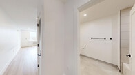 Located on the fifth floor at 337-339 Johnston Ave in Jersey City, NJ, Unit 504 is a thoughtfully designed studio that maximizes its efficient footprint through a clean, open layout. Light-toned hardwood flooring runs continuously throughout the main living space, reinforcing a sense of cohesion and warmth against the crisp white walls.

The combined kitchen and living area forms the heart of the unit. The kitchen is well-appointed with white shaker-style cabinetry extending to the ceiling, a subtle tile backsplash in a soft gray palette, light quartz countertops, and a full suite of stainless steel appliances including a gas range, over-the-range microwave, dishwasher, and refrigerator. The open-concept design allows the kitchen to flow seamlessly into the living area, which features recessed lighting and a window with city views, fitted with a wall-unit HVAC system for year-round climate control.

The bathroom showcases modern finishes, including large-format neutral wall tiles, a white vanity with a quartz countertop, matte black fixtures and hardware, a rounded rectangular mirror with integrated lighting, and clean tile flooring. The overall aesthetic throughout the unit is fresh, minimalist, and move-in ready.