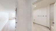 Located on the fifth floor at 337-339 Johnston Ave in Jersey City, NJ, Unit 504 is a thoughtfully designed studio that maximizes its efficient footprint through a clean, open layout. Light-toned hardwood flooring runs continuously throughout the main living space, reinforcing a sense of cohesion and warmth against the crisp white walls.

The combined kitchen and living area forms the heart of the unit. The kitchen is well-appointed with white shaker-style cabinetry extending to the ceiling, a subtle tile backsplash in a soft gray palette, light quartz countertops, and a full suite of stainless steel appliances including a gas range, over-the-range microwave, dishwasher, and refrigerator. The open-concept design allows the kitchen to flow seamlessly into the living area, which features recessed lighting and a window with city views, fitted with a wall-unit HVAC system for year-round climate control.

The bathroom showcases modern finishes, including large-format neutral wall tiles, a white vanity with a quartz countertop, matte black fixtures and hardware, a rounded rectangular mirror with integrated lighting, and clean tile flooring. The overall aesthetic throughout the unit is fresh, minimalist, and move-in ready.
