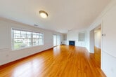 Located at 34 Great Pond Rd in Lunenburg, MA, this three-bedroom, two-bathroom home spans three floors and offers a well-organized, functional layout throughout. The main living level features a spacious open-concept area where the living room, dining room, and kitchen connect seamlessly. The living room is highlighted by warm hardwood floors, a classic fireplace flanked by built-in shelving, a ceiling fan, and large windows and sliding glass door access that fill the space with natural light. The kitchen is outfitted with rich wood cabinetry, dark granite countertops, stainless steel appliances, and a central island, all grounded by matching hardwood flooring. The dining area flows naturally between the two spaces. The upper floor hosts the three bedrooms, including a generously sized primary bedroom with its own walk-in closet featuring full wire shelving systems. The bathrooms include a well-appointed full bath with stone-tile flooring, a walk-in shower, and a window for natural light. A graceful staircase with wood railings and beadboard wainscoting adds architectural charm to the home. The lower level includes an attached garage with an automatic opener and an unfinished basement offering substantial storage or potential for future finishing.