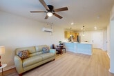 Located at 260 Spanish Moss Cir in Sebring, Florida, this single-story, one-bedroom, one-bathroom home offers a thoughtfully designed open-concept floor plan that maximizes every square foot. Light-toned luxury vinyl plank flooring runs throughout, creating a clean and cohesive aesthetic across all rooms.

The kitchen is a functional centerpiece, featuring a two-tone cabinet design with rich dark lower cabinets and natural wood upper cabinets, complemented by white countertops. Stainless steel appliances — including a range, built-in microwave, dishwasher, and refrigerator — provide a modern finish. A peninsula with pendant lighting above connects the kitchen seamlessly to the combined dining and living area, where a ceiling fan, wall-mounted mini-split HVAC unit, and large windows allow natural light and comfortable airflow throughout.

The bedroom is a quiet, well-proportioned retreat with a ceiling fan, a wide double-door closet, and a window with outdoor views. The full bathroom includes a tub/shower combo, a dark-cabinet vanity with a white countertop, a large mirror with overhead lighting, and light vinyl flooring. A dedicated laundry area houses a stacked washer and dryer unit, adding everyday convenience to this well-appointed home.
