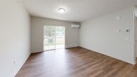 Located at 1022 E 29th St in Fremont, Nebraska, this one-bedroom, one-bathroom unit offers a thoughtfully designed single-floor layout with a comfortable, functional living experience. The open-concept living room and kitchen area is anchored by warm hardwood-style flooring, neutral toned walls, and a textured ceiling. Large sliding glass doors flood the living room with natural light and provide views of the surrounding greenery, while a wall-mounted mini-split unit ensures year-round climate control alongside baseboard heating. The kitchen is well-equipped with gray shaker-style cabinetry, light stone-finish countertops, and a full suite of stainless steel appliances including a refrigerator, electric range, and microwave. A peninsula with an integrated sink adds both prep space and visual separation from the living area. A dedicated in-unit laundry area with a full-size washer and dryer adds exceptional convenience. The bedroom features plush carpeting, a ceiling fan, a built-in closet, and a bright window with vertical blinds. The bathroom offers a walk-in shower stall with built-in grab bars, a bench seat, and brushed nickel fixtures. A built-in shelving closet adds additional storage to the unit.