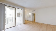 Located in the desirable Brentwood neighborhood of Los Angeles, this 2-bedroom, 2-bathroom residence offers a well-organized single-level layout with a clean, bright aesthetic throughout. The open kitchen and living room area forms the heart of the home, where light tile flooring, white cabinetry, granite countertops, and a full suite of appliances — including an electric range and refrigerator — create a functional and attractive space. The living room extends the feel of openness with warm hardwood-style flooring and access to a private balcony. Both bedrooms are generously proportioned, featuring the same hardwood-style floors, crisp white walls, and mirrored sliding closet doors that add depth and reflect natural light. The spacious primary bedroom includes dual mirrored closets for ample storage. A charming circular window in the second bedroom serves as a distinctive architectural detail. The two bathrooms are finished with tile flooring, white vanity cabinetry, and granite countertops; one includes a tub and sliding glass shower enclosure, while the other features a walk-in shower. A connecting hallway ties the layout together cohesively, making this a practical and comfortable Brentwood residence.